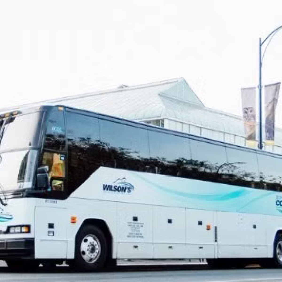 White tour bus labeled 'Connector' parked on the street.
